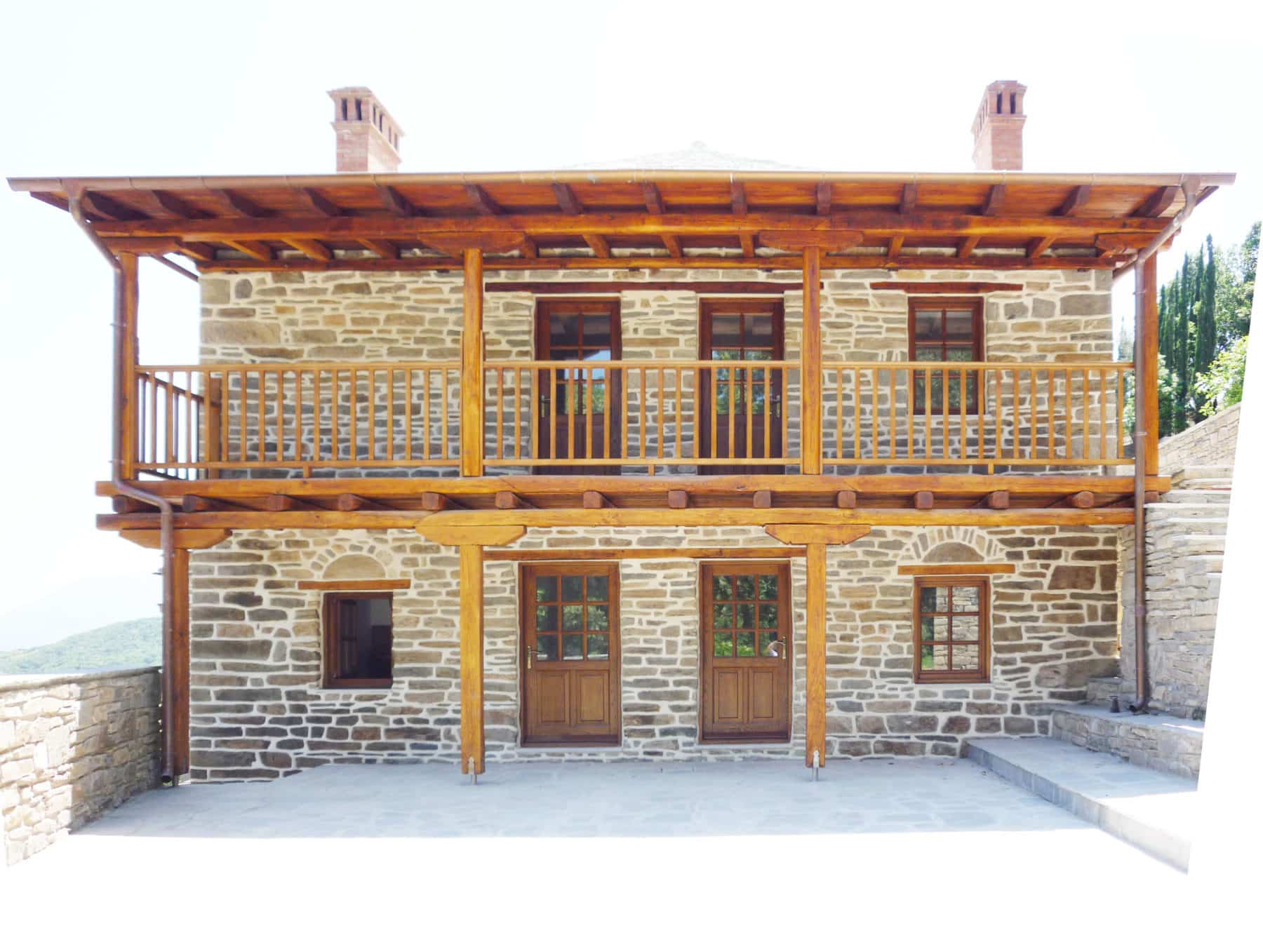 κτίριο με εισόδους παράθυρα και ξύλινο μπαλκόνι με στέγη από την Athos