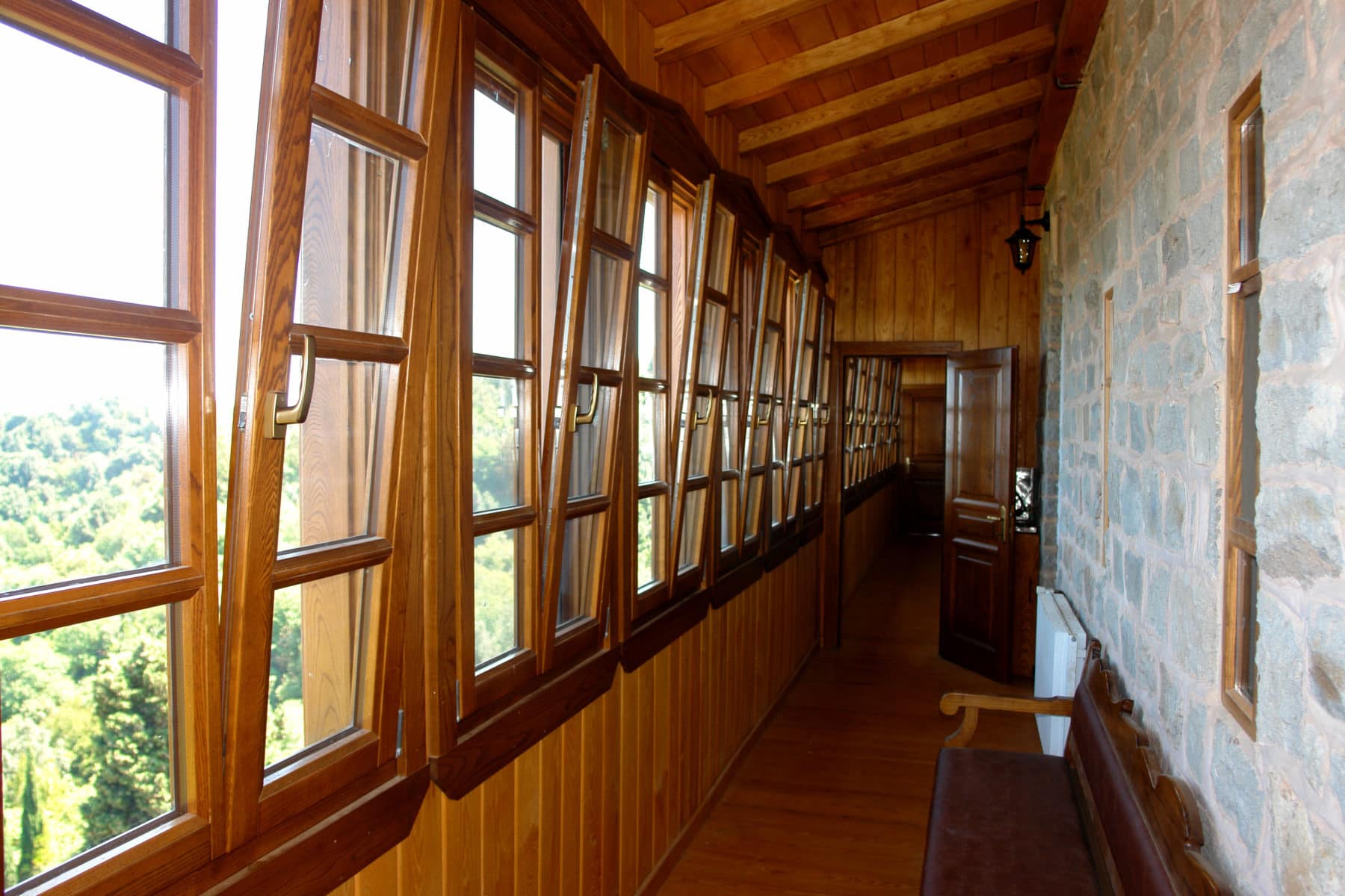 από ανακλινόμενα δίφυλλα ξύλινα παράθυρα με αέτωμα και ειδικό κατωκάσι